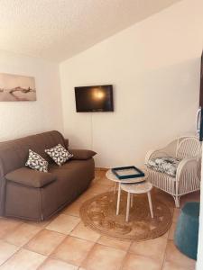 a living room with a couch and a table at Maison en corse in Santa-Maria-Poggio