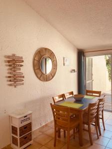a dining room with a table and chairs and a mirror at Maison en corse in Santa-Maria-Poggio