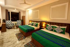 a hotel room with two beds and a chair at Hotel La Meridian, A Four Star Luxury Hotel & Resort - Haridwar in Haridwār