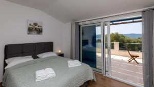 a bedroom with a bed and a balcony at Villa Olea by Villas Guide in Blace +22 photos