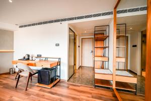 een kamer met een bureau en een stapelbed bij Nestlay Suites by TC One in Kozhikode