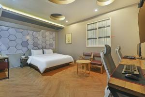 a bedroom with a bed and a desk with a computer at Palace Hotel in Ulsan