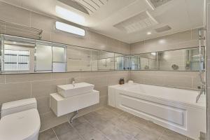 a bathroom with a tub and a toilet and a sink at Palace Hotel in Ulsan