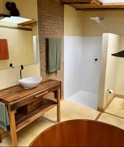 une salle de bain avec une vasque blanche sur une table en bois dans l'établissement Sítio Santo Antônio - Chalé com Ofurô, à Atibaia 10 autres photos