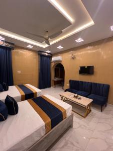 a hotel room with two beds and a couch at Gulberg Residency Hotel in Lahore