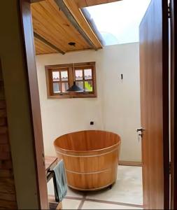 une grande baignoire en bois dans une pièce avec une fenêtre dans l'établissement Sítio Santo Antônio - Chalé com Ofurô, à Atibaia