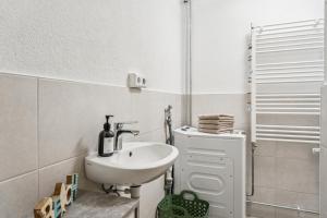 une salle de bain blanche avec lavabo et douche dans l'établissement Ferienwohnung am Bodensee - nur 10 Minuten zu Fuß zum Strand, à Langenargen