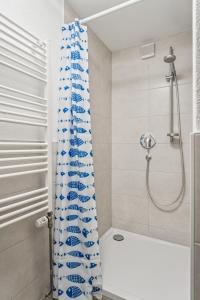 une salle de bain avec un rideau de douche et une baignoire dans l'établissement Ferienwohnung am Bodensee - nur 10 Minuten zu Fuß zum Strand, à Langenargen