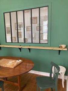 een tafel en een stoel en een spiegel aan een muur bij La Luciole in Périgueux