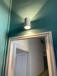 een badkamer met een spiegel en een lamp boven een deur bij La Luciole in Périgueux