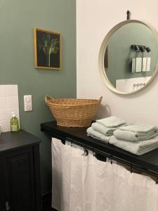 een badkamer met een spiegel en handdoeken op een aanrecht bij La Luciole in Périgueux +48 foto's