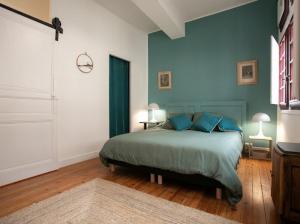a bedroom with a bed with blue walls at La luciole in Périgueux
