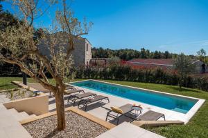 - une piscine dans une cour avec des chaises et un arbre dans l'établissement Mediterrane Steinvilla mit Privatpool, toller Aussicht, starkem WiFi, BBQ, à Majkusi