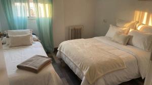 een slaapkamer met twee bedden met witte lakens en kussens bij Villa Eventos Biar - Private Pool in Biar +12 foto's