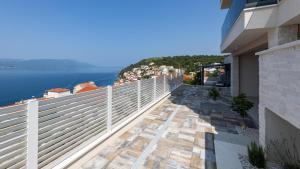 een balkon van een huis met uitzicht op het water bij Villa Sole Komarna by Villas Guide in Klek