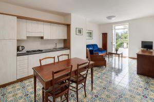 een keuken en eetkamer met een tafel en stoelen bij Residence L'Ulivo in Bellagio