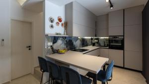 a kitchen with a table and blue chairs at Villa D Cube by Villas Guide in Duba