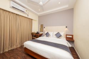 a bedroom with a large white bed in a room at The Grand Rajmahal in Bangalore