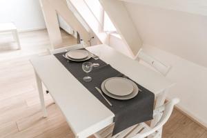 tavolo bianco da pranzo con piatti e bicchieri da vino di Studio Hyper centre - Dans Hotel Particulier - Charles le Téméraire a La Celle-sous-Gouzon Altre 7 foto