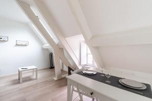 una stanza bianca con un tavolo da pranzo in un soppalco di Studio Hyper centre - Dans Hotel Particulier - Charles le Téméraire a La Celle-sous-Gouzon