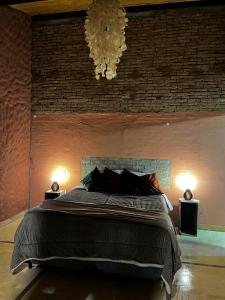 une chambre avec un grand lit et un mur de briques dans l'établissement Sítio Santo Antônio - Chalé com Ofurô, à Atibaia