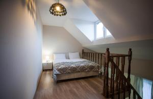 a bedroom with a bed and a staircase with a window at Hotel Donata in Gudauri