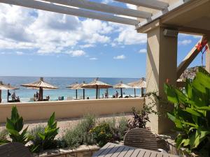 a view of the beach from a patio with umbrellas at Hotel SPICH - Pearl Beach Resort in Čanj