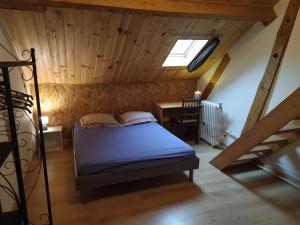 ein Schlafzimmer mit einem Bett und einem Schreibtisch auf einem Dachboden in der Unterkunft gite 2-6 personne en Périgord in Thiviers
