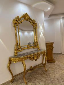 une coiffeuse avec un miroir sur un mur dans l'établissement Almajidy Villa, au Caire