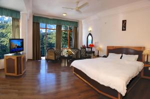 una camera da letto con un letto e una televisione di Lords Residency a Manāli