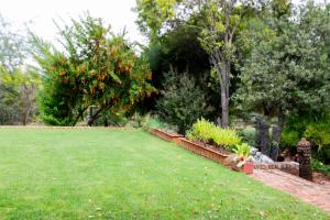 a garden with a lawn and some bushes and trees at Buchan's Corner Unit 2 in Hartbeespoort +1 photo