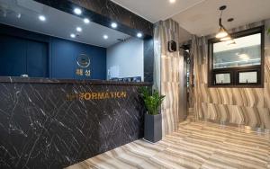 a lobby with a counter and a blue wall at Hotel Haeseong in Changwon