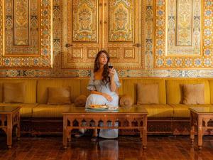 een vrouw die op een salontafel in een kamer zit bij Mövenpick Resort Petra in Wadi Musa