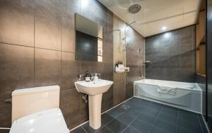 a bathroom with a sink and a toilet and a tub at Hotel Haeseong in Changwon +43 photos