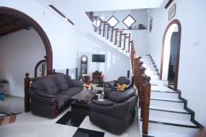 a living room with two chairs and a staircase at Sajee Villa in Hikkaduwa