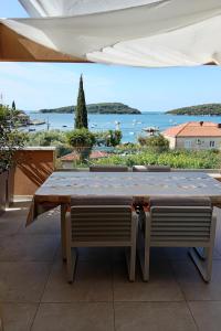 een tafel en stoelen met uitzicht op het water bij Apartman Twins 2 by Villas Guide in Ðurinići