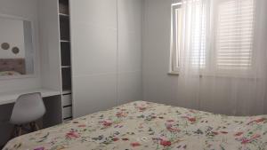 een slaapkamer met een bed, een raam en een stoel bij Apartman Twins 2 by Villas Guide in Ðurinići