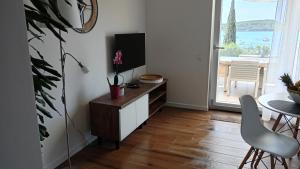 een woonkamer met een dressoir met een tv en een tafel bij Apartman Twins 2 by Villas Guide in Ðurinići