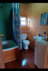 a bathroom with a tub and a toilet and a sink at Cabaña coñico in Coñico