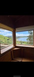 two windows in a room with a view of the ocean at Cabaña coñico in Coñico