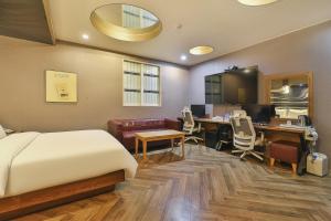 a bedroom with a bed and a desk with a computer at Palace Hotel in Ulsan