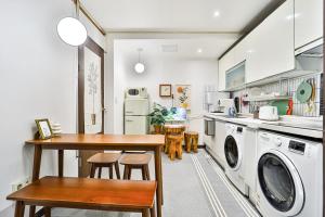 una cucina con tavolo e lavatrice/asciugatrice di MIIN Stay a Seul