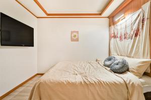 una camera da letto con un letto e una TV a schermo piatto di MIIN Stay a Seul