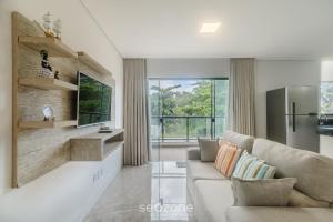 ein Wohnzimmer mit Sofa und Fernseher in der Unterkunft Estadia completa com piscina e a 350m da Praia PRY in Porto Seguro