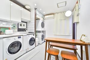 una cucina con lavatrice e tavolo in legno di MIIN Stay a Seul Altre 11 foto