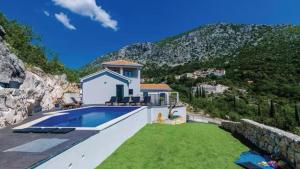 a house with a swimming pool and a mountain at Villa Bohemia by Villas Guide in Dubrovnik
