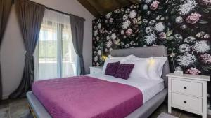 a bedroom with a purple bed with a floral wall at Villa Bohemia by Villas Guide in Dubrovnik +27 photos