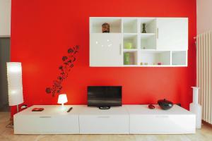 una parete rossa con una TV su un mobile bianco di PrimoPiano - Sporting Mirasole a Opera