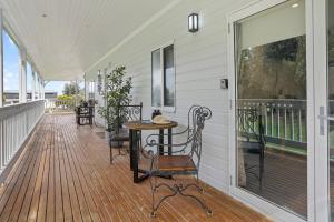 a porch with a table and chairs on it at Galbraith Beach Studio 1 - steps away from beach in Marengo