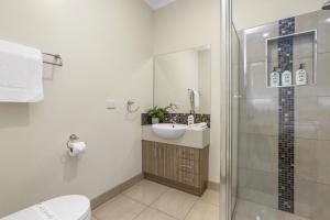a bathroom with a shower and a sink and a toilet at Galbraith Beach Studio 1 - steps away from beach in Marengo